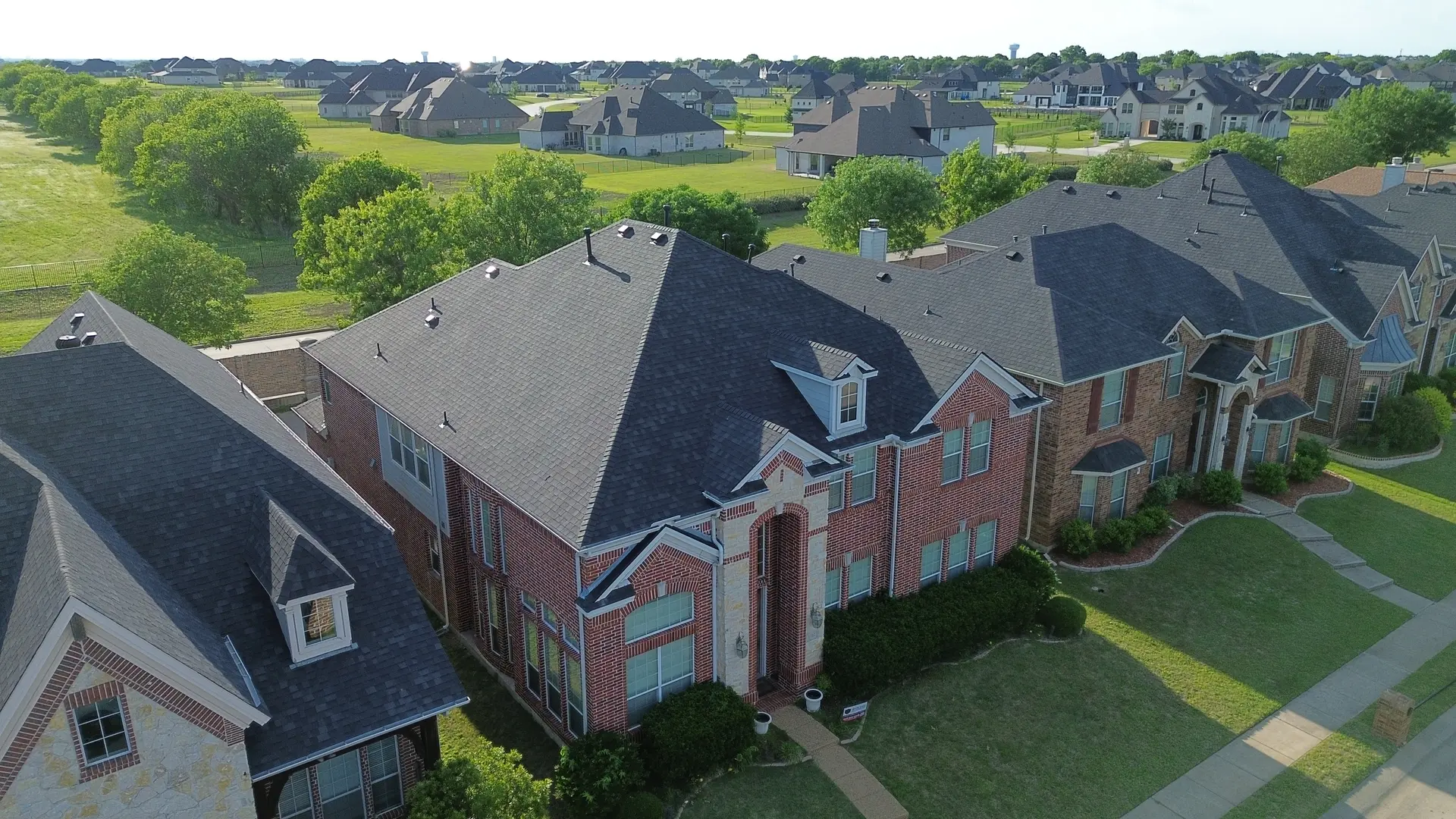 Aerial view of Plano homes with new architectural shingle roofs installed by IronCrest Construction Group
