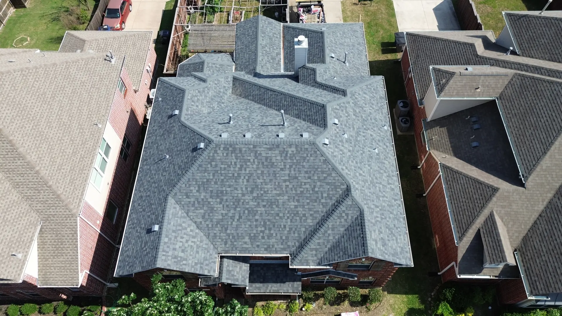 Aerial view of a completed gray shingle roof replacement in the Dallas area